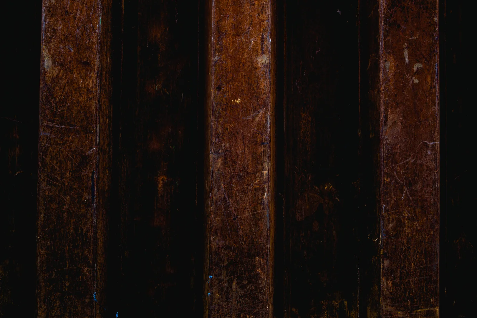 Close view of dark metal showing patches of brown surface rust.