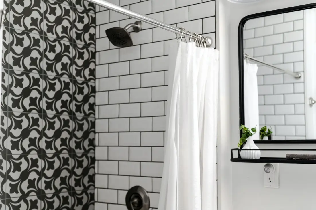 Shower curtain rings attached to a white curtain in a modern bathroom setting.
