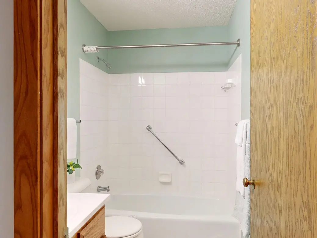 A bathroom with a shower curtain rod securely mounted above a bathtub.