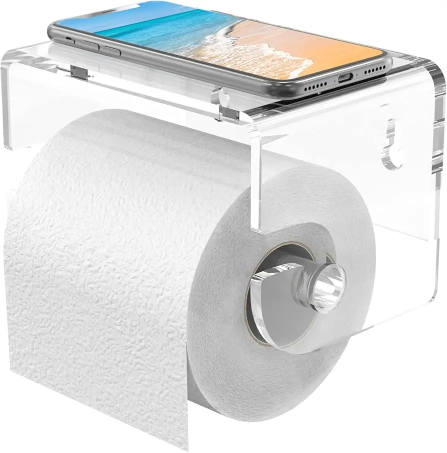 A clear acrylic toilet paper holder with a roll of toilet paper and a smartphone resting on top.