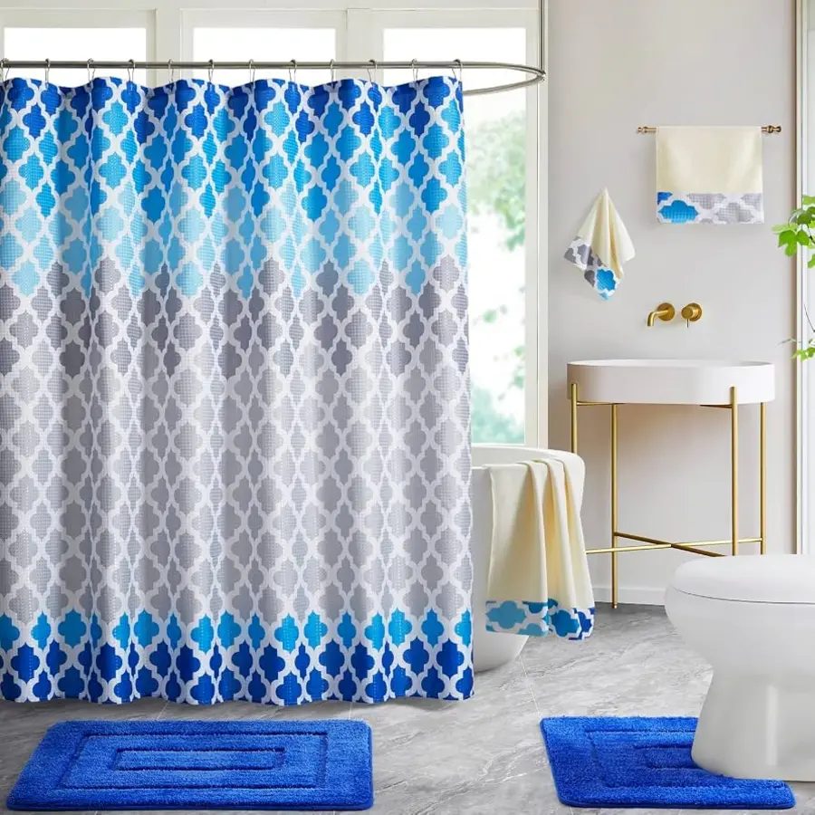 A bathroom featuring a blue and gray patterned shower curtain, matching towels, and a blue bath mat.