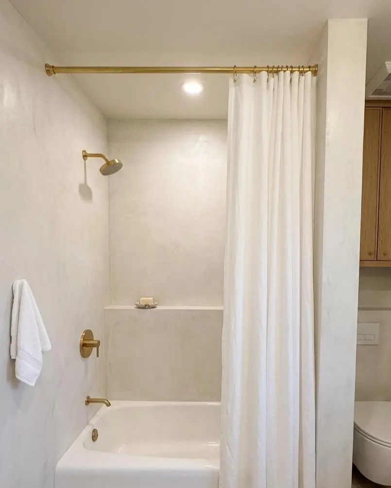 Shower curtain with rod in a bathroom, water leak prevention setup.