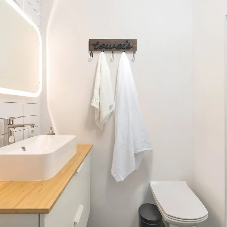 Compact bathroom with a towel bar and two white towels hanging on hooks.